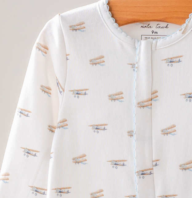 Baby outfit with airplane pattern on a plain background