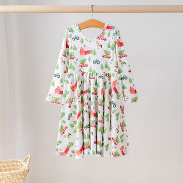 Organic cotton long-sleeve girls’ twirl dress with festive farm print featuring red barns, tractors, Christmas trees, and animals. Eco-friendly kids holiday clothing