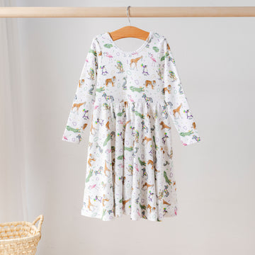 Organic cotton long-sleeve girls’ twirl dress with Mardi Gras parade animal print featuring tigers, zebras, flamingos, and alligators. Eco-friendly kids clothing.